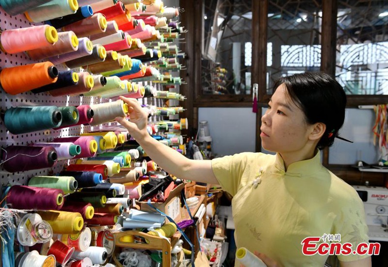 Msichana anayejikita katika kufuma vifungo vya nguo vya jadi vya China