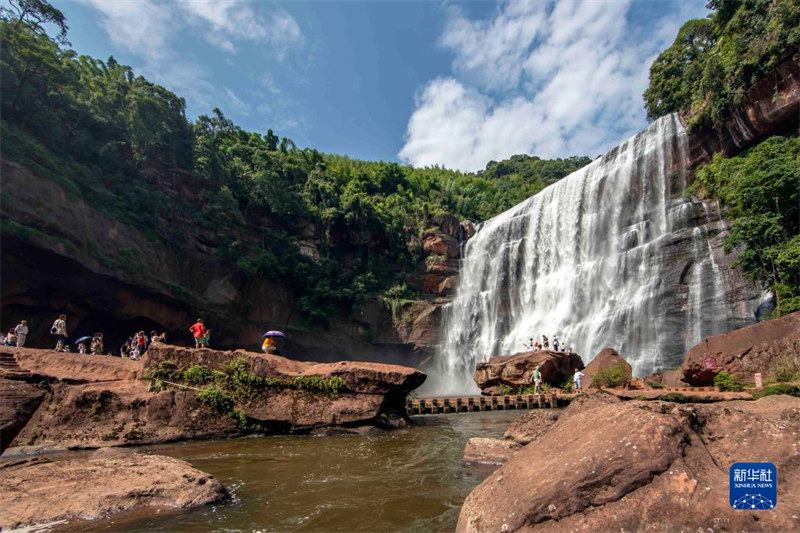 Agosti 3，watalii wakitembelea katika maporomoko ya maji ya eneo la vivutio la Danxia la Mji wa Chishui.