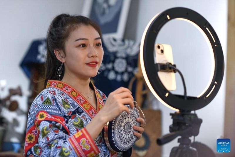 Zhang Juanjuan akijulisha bidhaa zake za batiki zenye ubunifu wa kitamaduni kwa kupitia mubashara wa intaneti kwenye ofisi yake ya DIY katika mji wa Anshun, Mkoa wa Guizhou wa Kusini Magharibi mwa China Agosti 18, 2022. 
