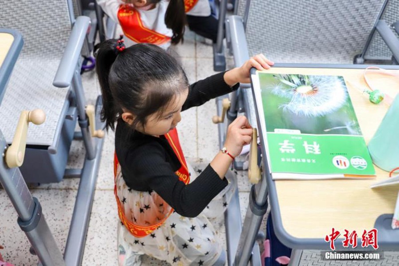 Mwanafunzi wa mwaka wa kwanza akiinua meza ili kuitumia kwa kupata lepe wakati wa mapumziko ya mchana katika shule ya msingi ya Wilaya ya Yunyang ya Chongqing, China tarehe 6, Septemba, 2022. (Picha: China News Service/Tan Qiyun)