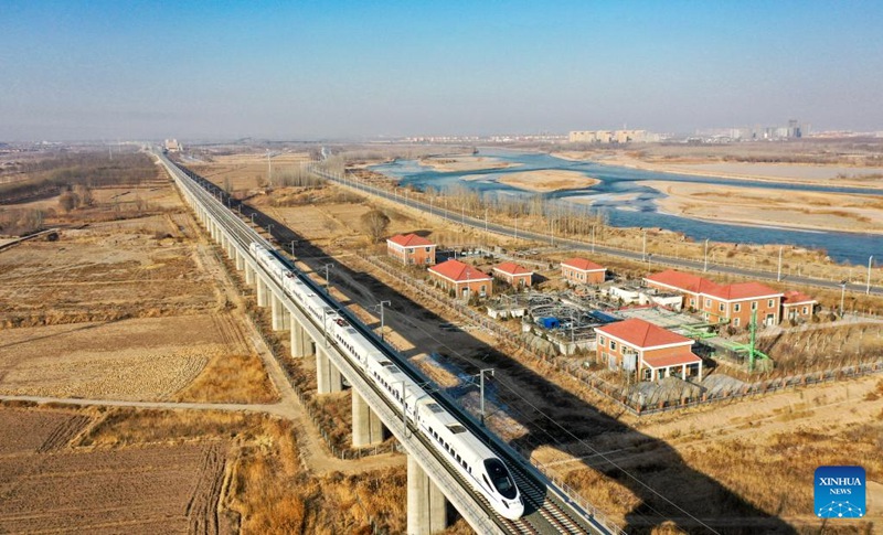 Picha hii iliyopigwa Tarehe 29 Desemba 2022 ikionyesha treni ikipita kando ya Mto Manjano kwenye Mji wa Zhongwei, katika Mkoa unaojiendesha wa Ningxia, Kaskazini-Magharibi mwa China. Njia mpya ya reli ya mwendo kasi yenye urefu wa kilomita 219, inayounganisha miji ya Zhongwei na Lanzhou Kaskazini-Magharibi mwa China, imeanza kufanya kazi siku ya Alhamisi. Ikiwa imeundwa kukimbia kwa kasi ya kilomita 250 kwa saa, reli hiyo mpya inayounganisha njia ya reli ya Yinchuan-Zhongwei, imepunguza muda wa kusafiri kati ya Yinchuan na Lanzhou, miji mikuu ya Mkoa unaojiendesha wa Ningxia na Mkoa wa Gansu, hadi chini ya saa tatu. Reli hii ya mwendo kasi pia inakamilisha sehemu ya mwisho ya njia ya reli inayounganisha mikoa ya Shaanxi, Gansu na Ningxia. (Xinhua/Feng Kaihua)