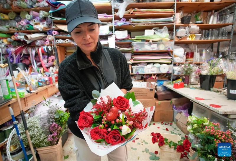Muuza maua akionyesha shada la maua kabla ya Siku ya Wapendanao kwenye duka la maua huko Vancouver, British Columbia, Canada, Februari 13, 2023. (Picha na Liang Sen/Xinhua)