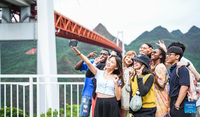 Wanafunzi wa kigeni nchini China wakijipiga picha wakati wakitembelea daraja la Mto Baling, Mkoa wa Guizhou, Kusini-Magharibi mwa China, Juni 3, 2023. (Xinhua/Tao Liang)