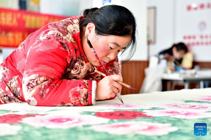 Mkulima akichora picha ya maua ya Peony kwenye studio iliyoko Wilaya ya Juye ya Mji wa Heze, Mkoa wa Shandong, Mashariki mwa China, Desemba 2, 2023. (Xinhua/Guo Xulei)