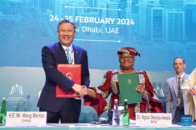 Waziri wa Biashara wa China Wang Wentao (kushoto) akiwa katika picha ya pamoja na Mkurugenzi Mkuu wa WTO Ngozi Okonjo-Iweala baada ya kutia saini Mkataba mpya wa Makubaliano kuhusu Mpango wa China kwenye mazungumzo ya raundi ya 12 ya China kuhusu makubaliano na WTO uliofanyika Abu Dhabi, Falme za Kiarabu, Februari 25, 2024. (WTO/ Xinhua)