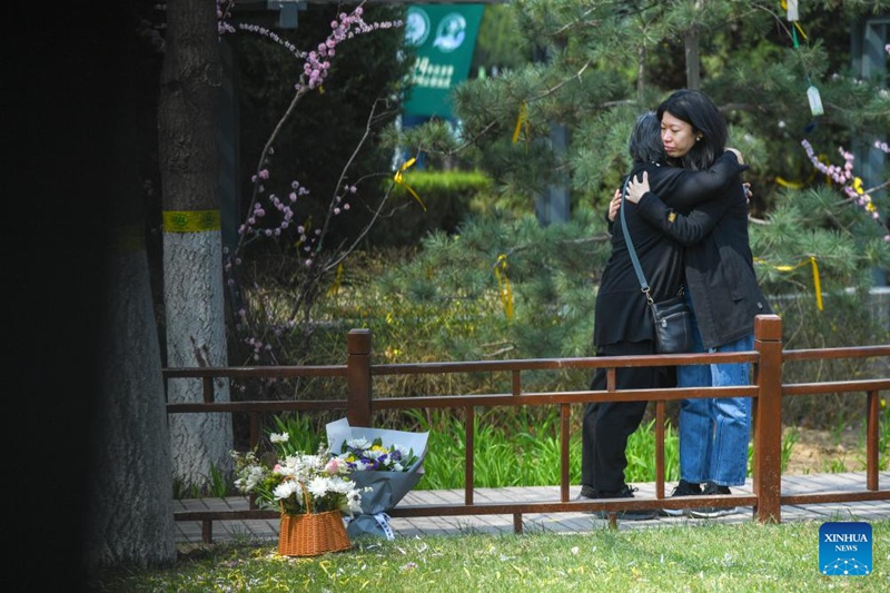 Watu wakiwa wamekumbatiana baada ya kuweka maua kuomboleza watu waliofariki kwenye makaburi ya mjini Beijing, Aprili 2, 2024. (Xinhua/Ju Huanzong)