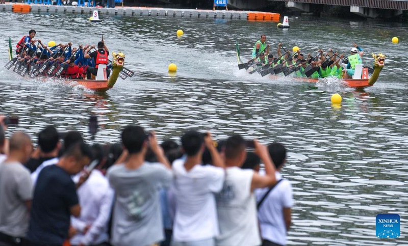 Tarehe 10, Juni, 2024, watu wakitazama mashindano ya mashua ya dragon kwenye Wilaya ya Zhenyuan, Eneo linalojiendesha la kabila la Wamiao na Wadong ya Guidongnan la Mkoa wa Guizhou, China. (Picha na Yang Wenbin/Xinhua)