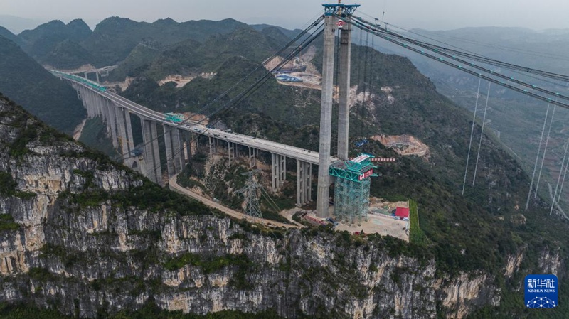 Wafanyakazi wa shirika la daraja la Kundi la Ujenzi na Mawasiliano la Guizhou, China wakifanya maandalizi ya kufunga boriti ya kwanza ya chuma ya daraja. (Picha ilipigwa Novemba 4)