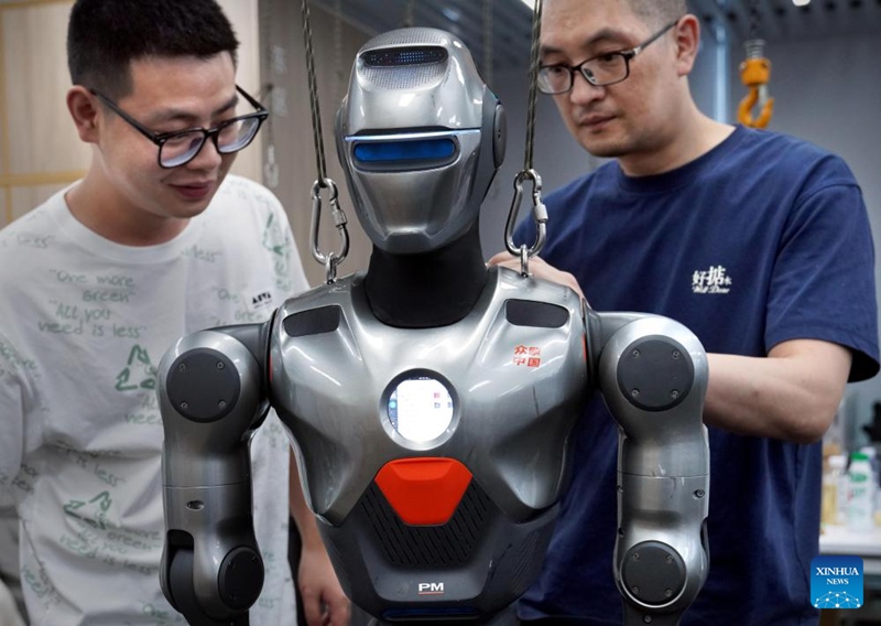 Wafanyakazi wakirekebisha mifumo ya roboti ya umbo la binadamu kwenye kampuni ya roboti mjini Shenzhen, Mkoa wa Guangdong, kusini mwa China, Juni 25, 2025. (Xinhua/Li An)